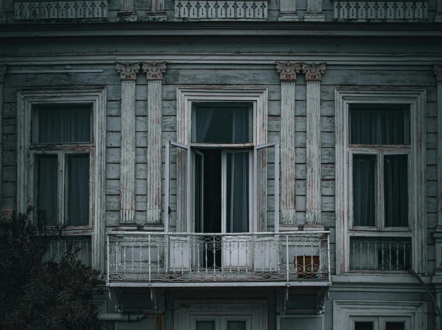 En mørk bygning med en åben terrassedør. 